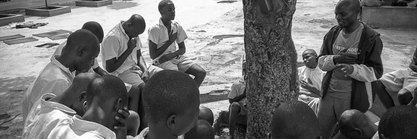 chaplain prays with a group boys